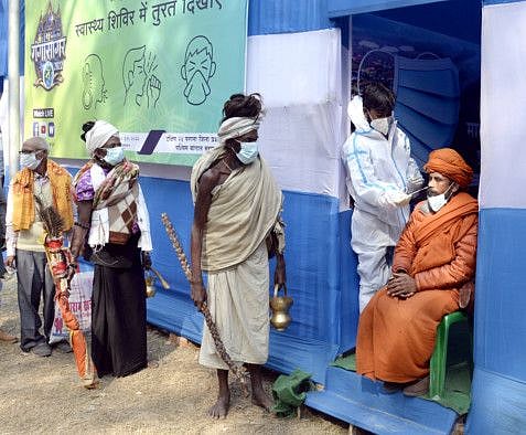 A healthcare worker collects a nasal sample of a sadhu for the COVID-19 test done before attending Ganga Sagar Mela in South 24 Parganas ahead of Makar Sankranti, at Babughat, in Kolkata on Friday. 