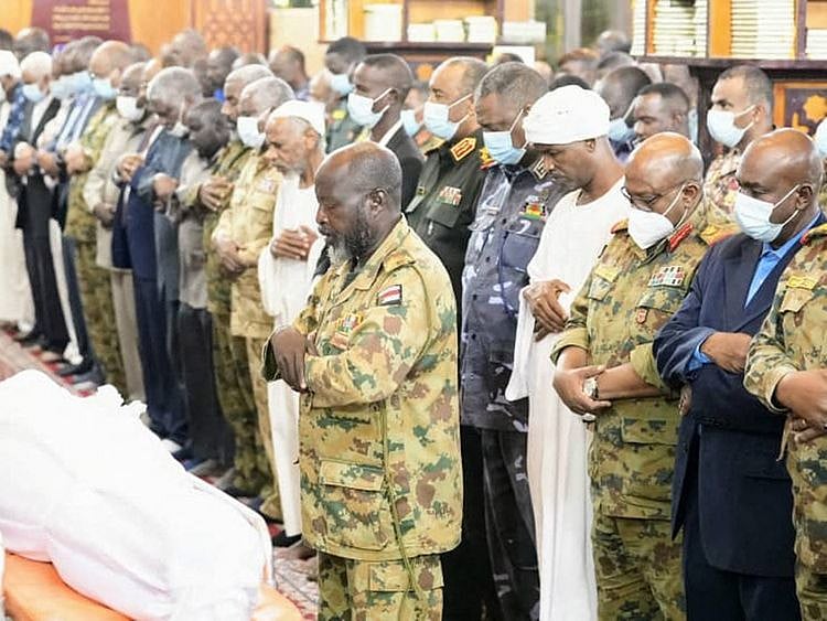 A handout picture released by the official Sudan News Agency's (SUNA) twitter account on January 13, 2022, shows Sudan's top general Abdul Fattah Al Burhan attending the funeral prayer for slain Brigadier General Ali Bareema Hamad of the Central Reserve Forces, in the capital Khartoum.  