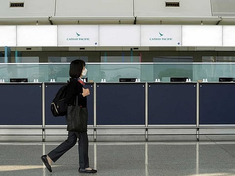 A woman walks past empty counters of Cathay Pacific at Hong Kong International Airport following fresh measures to control coronavirus (COVID-19) infections in Hong Kong, China January 11, 2022.