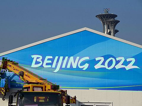 In this file photograph taken on January 4, 2022, banner is being set up on the sign of a building at the Beijing Olympic Park in Beijing