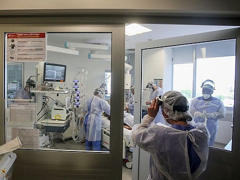 Medical workers take care of a COVID-19 patient at the intensive care unit (ICU) of Hospital das Clinicas, in Porto Alegre, Brazil. 