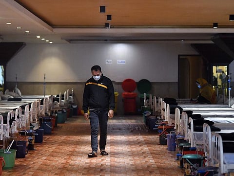 A COVID-19 infected patient takes a walk in a temporarily converted isolation ward at a banquet hall, in view of the Omicron-driven Coronavirus surge, in New Delhi on January 14, 2022.. 