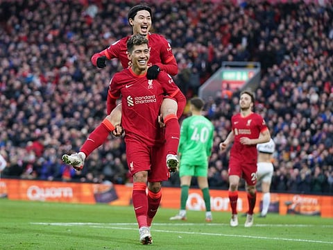 Liverpool's Takumi Minamino, top, celebrates with Liverpool's Roberto Firmino after scoring his side's third goal during an English Premier League match between against Brentford at Anfield in Liverpool, England.