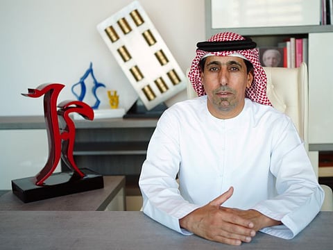 Jamal Habroush Al Suwaidi, Emirati artist and founder of Habroosh Art Foundation, with a model of the red sculpture 'Love'.