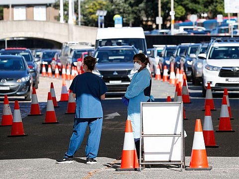 Healthcare workers wait for the next vehicle at a COVID-19 testing clinic as the Omicron variant continues to spread in Sydney. 