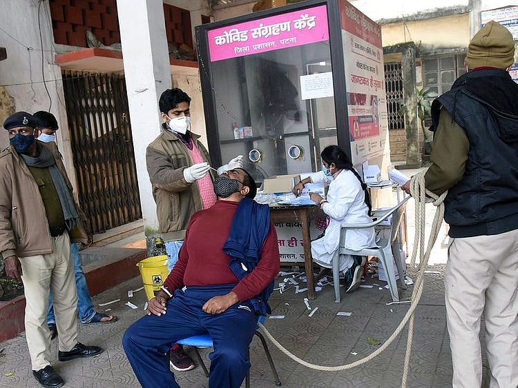 A healthcare worker collects a nasal swab sample of a prisoner for the COVID-19 test who was to be produced at Civil Court, in wake of the recent surge in Omicron-driven Coronavirus cases, in Patna.