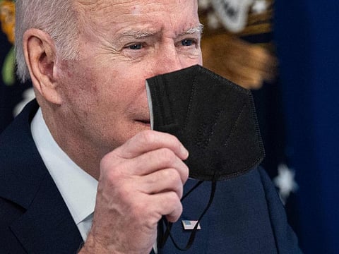 US President Joe Biden holds up a KN95 mask as he delivers an update on his Administrations whole-of-government COVID-19 surge response at the White House in Washington, DC.