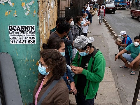 People line up to undergo discard tests and get vaccinated against COVID-19 at a free mobile testing facility set by Limas municipality in the populous district of La Victoria on January 12, 2022. 