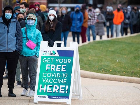 People wait in line at a walk-up vaccination site in Washington, DC. 