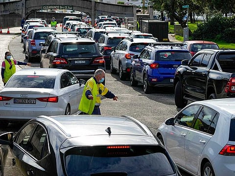 Traffic marshals direct vehicles at a drive-thru COVID-19 testing clinic at Bondi Beach in Sydney, Australia, on Jan. 8, 2022. Australia on Friday, Jan. 21, reported its deadliest day of the pandemic with 80 coronavirus fatalities, as an outbreak of the omicron variant continued to take a toll.