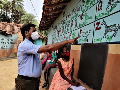School principal Sapan Kumar from Dumka in Jharkhand teaches children using mud walls as blackboards. 