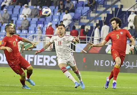 UAE's forward Caio Canedo (centre) tries to go past Syria's defenders Omar Midani (right) and Fahd Youssef during the 2022 Qatar World Cup Asian qualifiers at Al Maktoum stadium in Dubai on Thursday.
