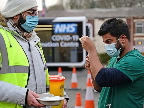 A health service worker draws up a dose of vaccine at a drive-through NHS (National Health Service) vaccination centre outside Ewood Park, Blackburn Rovers Football Club in Blackburn in north-west England.
