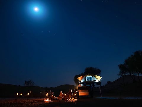 Campers enjoying a pristine location in the Dubai desert under the winter night sky 
