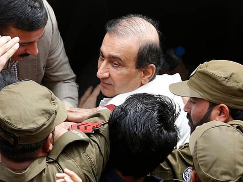 Pakistani police officers escort Mir Shakil-ur-Rehman owner of Jang Group of Newspapers to an anti-graft court in Lahore on March 13, 2020.