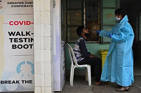 A health worker takes swab sample from a man to test for the COVID-19 in Chennai on January 20, 2022. 