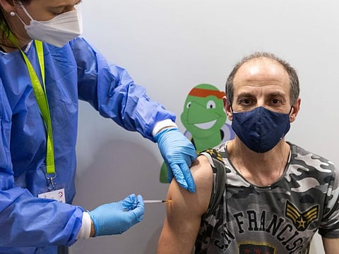 A person gets vaccinated against the COVID-19 virus as the compulsory COVID-19 vaccination starts in Vienna, Austria, Friday, Feb. 4, 2022.