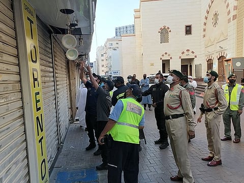 Dubai Police's rescue team at work to rescue the man who was trapped in a shop billboard in the Naif area on Friday. 