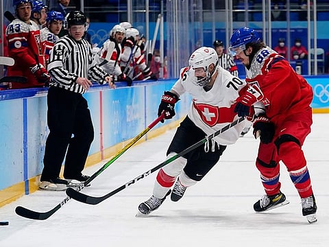 Switzerland's Denis Hollenstein (70) moves the puck against Czech Republic's Libor Sulak (88) during their preliminary round men's hockey game at the 2022 Winter Olympics on Friday.