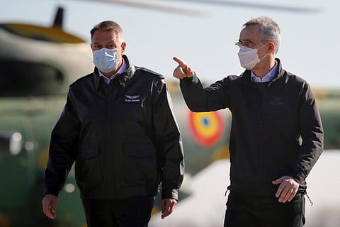 NATO Secretary General Jens Stoltenberg, right, and Romania's President Klaus Iohannis inspect the Mihail Kogalniceanu airbase, near the Black Sea port city of Constanta, eastern Romania, Friday, Feb. 11, 2022.