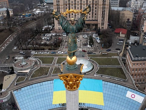 The Independence Monument is seen over Kyiv's Maidan Square in front of a Ukrainian national flag that was displayed on the occasion of the Day of Unity, in Kyiv, Ukraine, on February 16, 2022. As Western officials warned a Russian invasion could happen as early as today, the Ukrainian President Zelenskyy called for a Day of Unity, with Ukrainians encouraged to raise Ukrainian flags across the country.  