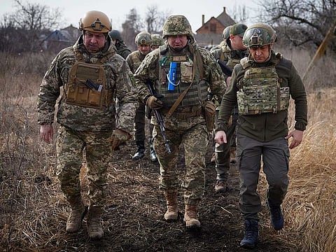 In this handout photo provided by the Ukrainian Presidential Press Office, Ukrainian President Volodymyr Zelenskyy, right, pays a visit to the front line in Donetsk region, eastern Ukraine, Thursday, Feb. 17, 2022. 