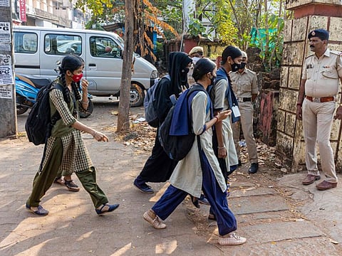 Students of government pre-university college in Kundapur town arrive in the premises of the educational institute in Udupi district in India's Karnataka state on February 16, 2022, after schools reopened in southern India under tight security after authorities banned public gatherings following protests over Muslim girls wearing the hijab in classrooms.