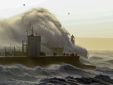 Waves crash against the sea wall at Porthcawl, south Wales.