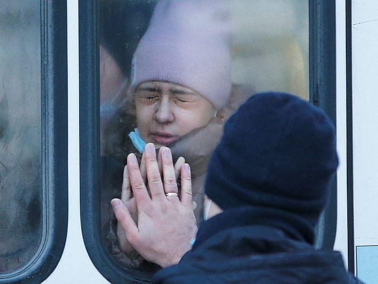 A woman says goodbye to her father through a bus window during the evacuation of local residents to Russia, in the rebel-controlled city of Donetsk, Ukraine, on February 19, 2022.  