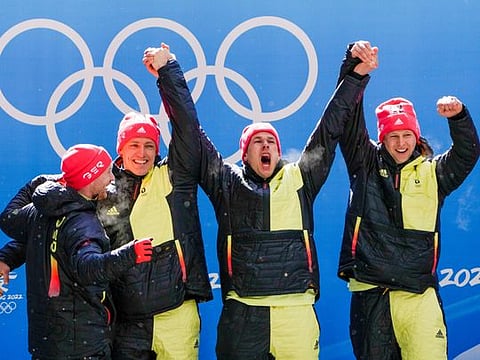 Francesco Friedrich, Thorsten Margis, Candy Bauer and Alexander Schueller, of Germany, celebrate winning the gold medal in the 4-man at the 2022 Winter Olympics in the Yanqing district of Beijing.