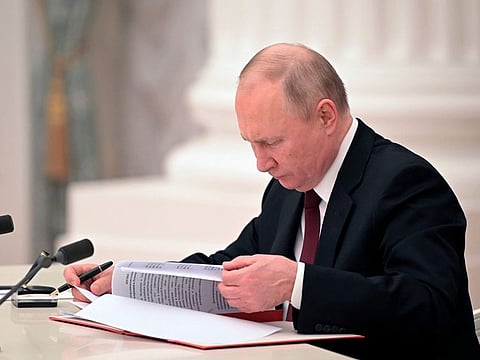 Russian President Vladimir Putin signs a document recognising the independence of separatist regions in eastern Ukraine in the Kremlin in Moscow, Russia, Monday, Feb. 21, 2022.