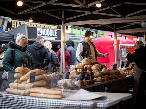 Customers shop for bread on a market stall in Walthamstow, east London. The UK still has Europe’s highest coronavirus toll after Russia, with more than 161,000 recorded deaths.