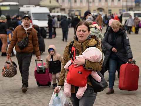 Evacuees from eastern Ukraine are seen outside the railway station in western Ukrainian city of Lviv on March 2, 2022. - Russia steps up its bombing campaign and missile strikes on Ukraine's cities on March 2, 2022. (Photo by Yuriy Dyachyshyn / AFP)