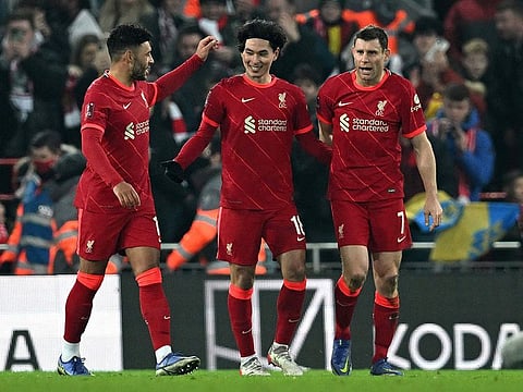 Liverpool’s Takumi Minamino (C) celebrates scoring his team’s second goal with James Milner (R).