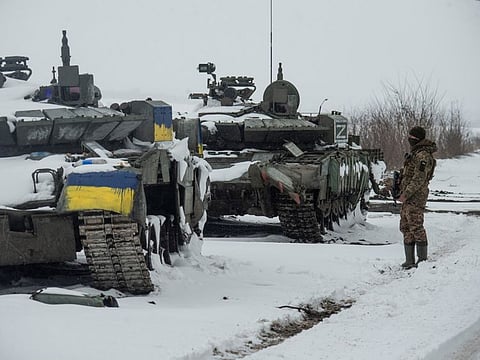 A Ukrainian serviceman stands near captured Russian tanks, one painted in the color of the Ukrainian national flag and the other marked with the letter ''Z'', amid the Russian attack on Ukraine, in the north of the Kharkiv region, on March 4, 2022. 