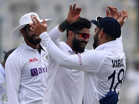 India's Ravindra Jadeja (centre) celebrates with teammate Virat Kohli (right) after the dismissal of Sri Lanka's Lahiru Kumara during the third day of the first Test cricket match between India and Sri Lanka at the Punjab Cricket Association Stadium in Mohali.