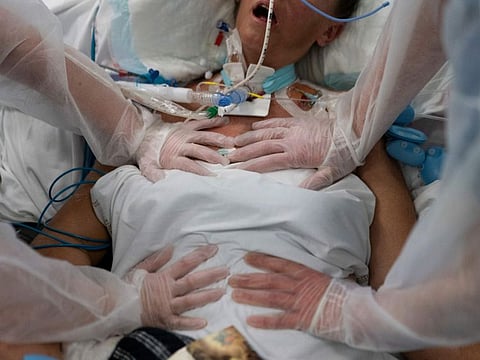 Nurses perform timed breathing exercises on a COVID-19 patient on a ventilator in the intensive care unit at the la Timone hospital in Marseille, southern France, on December 31, 2021. 