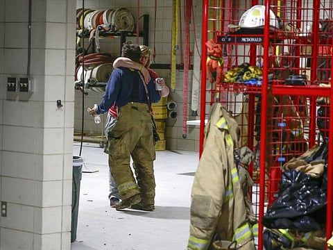 Members of the Winterset Fire Department embrace after a long evening responding to emergency calls after a tornado touched down west of Winterset, Iowa, killing multiple people and leveling homes on Saturday, March 5, 2022.  