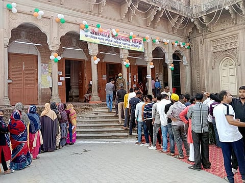 Voters form lines to cast their ballot for the seventh and final phase of the Uttar Pradesh Assembly Elections, at a polling station, in Mirzapur on Monday, Mar 7, 2022.