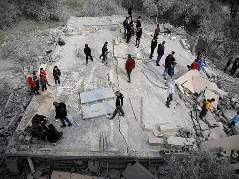 People stand at the house of a Palestinian man after it was blown up by Israeli forces, near Jenin in the Israeli-occupied West Bank, March 8, 2022. 