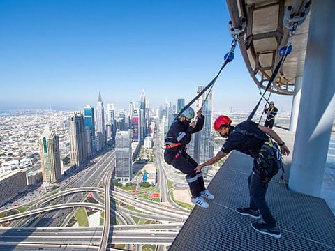 Walking along the edge of Sky Views Dubai | Glass slide | Sky Views Observatory