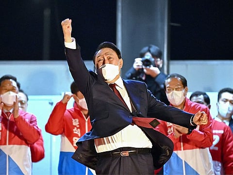 South Korea's new president-elect Yoon Suk Yeol of the main opposition People Power Party gestures to his supporters as he is congratulated outside the party headquarters in Seoul on March 10, 2022.  