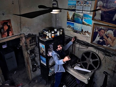 Kassem Istanbouli, actor, director and founder of the Tyro Association for Arts, inspects a movie tape at Empire Cinema in the northern city of Tripoli, Lebanon.