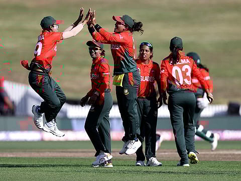 Bangladesh’s Fahima Khatun (left) and Rumana Ahmed (centre) celebrate the wicket of Pakistan's Nida Dar during the 2022 Women's Cricket World Cup match at Seddon Park in Hamilton on Monday. A batting collapse in Pakistan ranks handed Bangladesh their first-ever win the showpiece.
