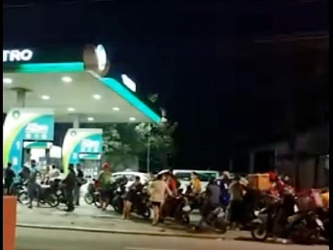 Motorists queue up at a fuel pump before midnight on Monday, March 14, 2022 before fuel prices took the biggest jump so far this year.
