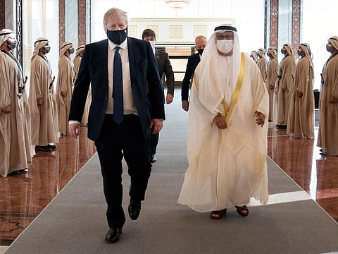  British Prime Minister Boris Johnson, left, inspects the honor guard as he arrives at Abu Dhabi airport for his visit to the United Arab Emirates, Wednesday, March 16, 2022. 