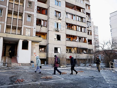 Residents return to a damaged residential building that was hit by an intercepted missile, in Kyiv, on March 17, 2022. 