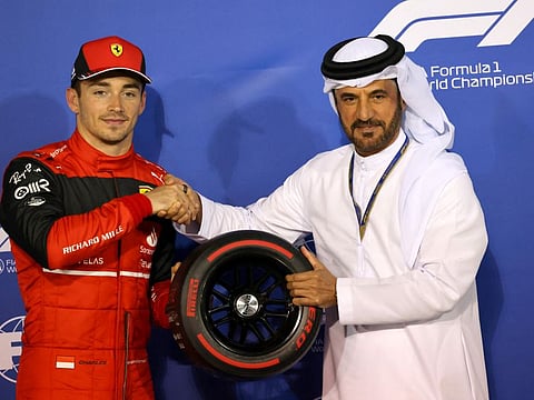 Ferrari's Charles Leclerc is presented the pole position trophy by FIA president Mohammed Ben Sulayem.