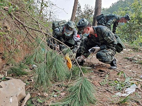 This photo taken on March 21, 2022 shows paramilitary police officers conducting a search at the site of the China Eastern Airlines plane crash in Tengxian county, Wuzhou city, in China's southern Guangxi region. - A China Eastern passenger jet carrying 132 people crashed onto a mountainside in southern China on March 21 causing a large fire, shortly after losing contact with air traffic control and dropping thousands of metres in just three minutes. (Photo by CNS / AFP) / China OUT