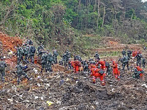 In this photo released by Xinhua News Agency, rescue workers search for the black boxes at a plane crash site in Tengxian county, southwestern China's Guangxi Zhuang Autonomous Region, Tuesday, March 22, 2022.